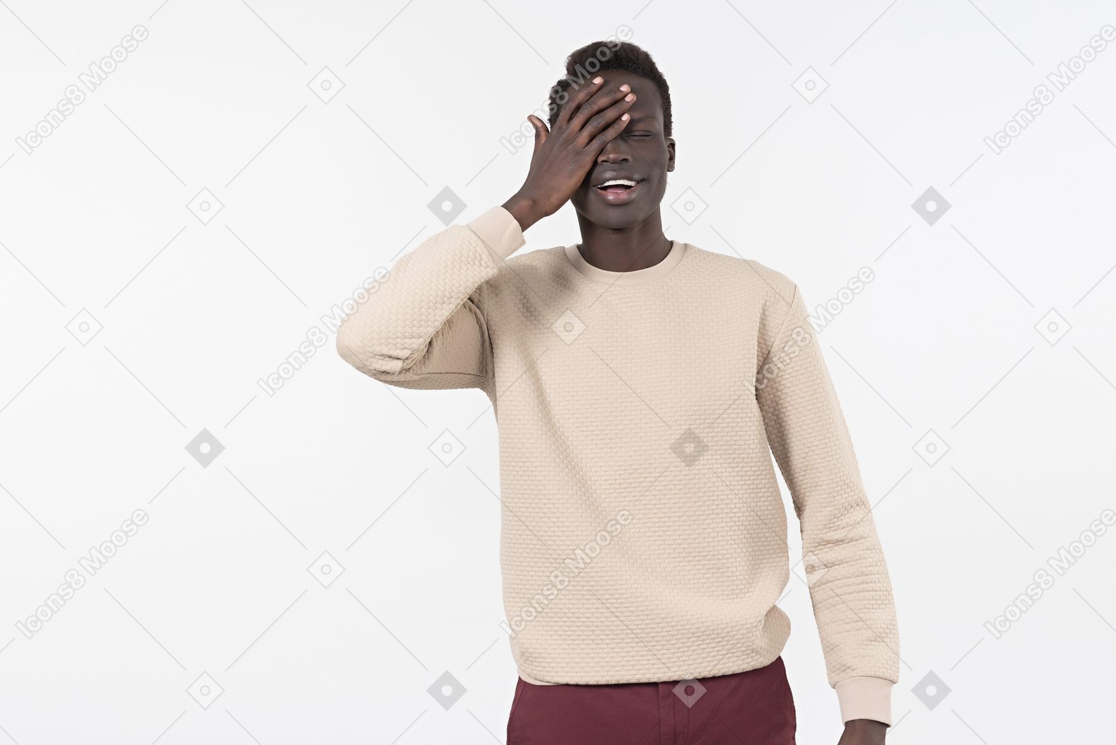 Un jeune homme noir dans un pull gris debout seul sur le fond blanc