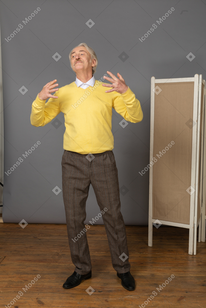 Vista frontal de un anciano complacido gesticulando