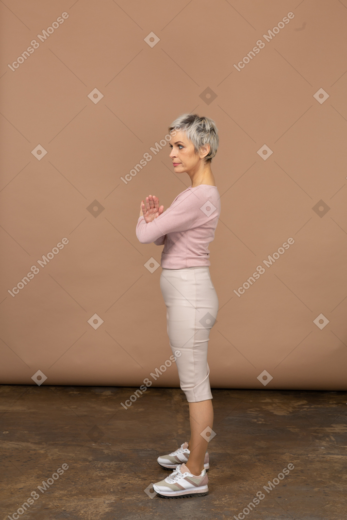 Vista lateral de una mujer en ropa casual mostrando gesto de parada