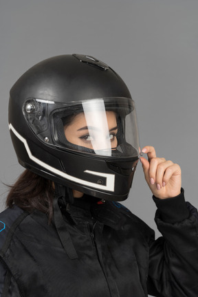 Una motociclista che chiude una visiera del casco