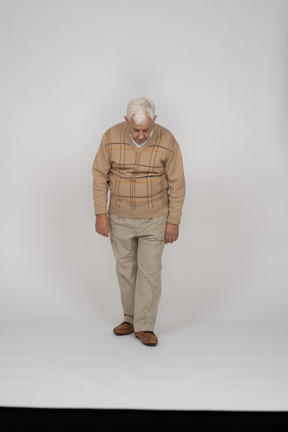 Vista frontale di un vecchio in abiti casual che guarda in basso