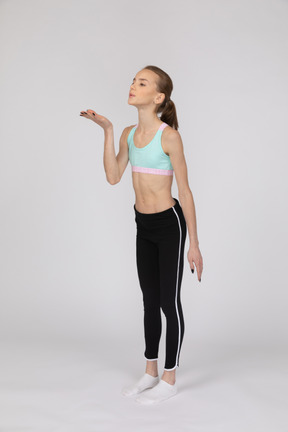 Side view of a teen girl in sportswear raising hand and arguing