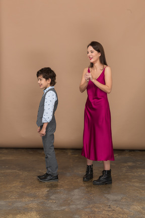 Woman holding her own hand and boy standing near her