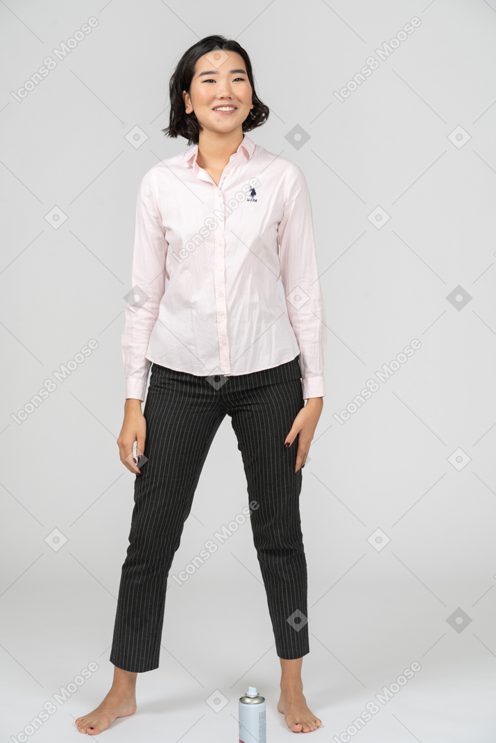 Mujer feliz en ropa de oficina posando con los brazos a los lados