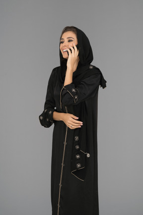 Smiling muslim woman talking on a phone