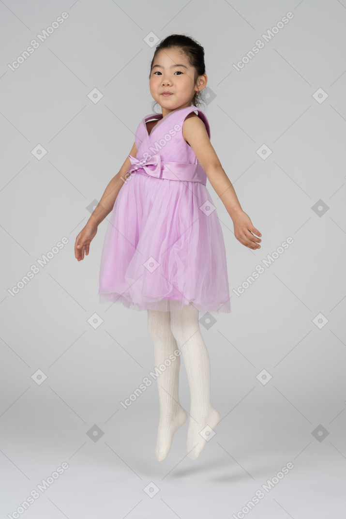 Girl in a pink dress levitating