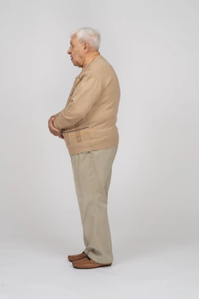 Side view of an old man in casual clothes standing still