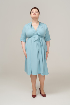 Vista frontal de uma mulher de vestido azul fazendo caretas