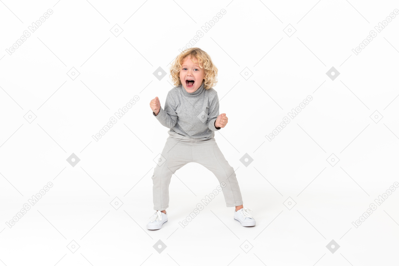 Super excited kid boy standing with fists clenched