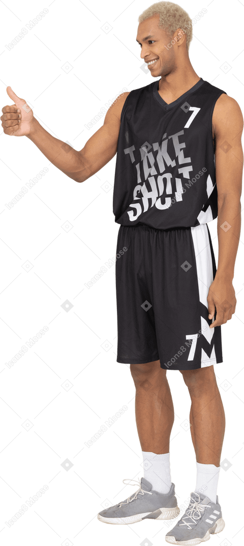 Vista di tre quarti di un giovane giocatore di basket maschile che mostra il pollice in su
