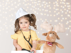 A little girl playing doctor with a stuffed animal