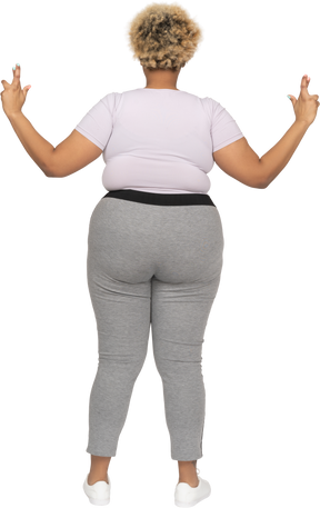 Plump woman keeping with fingers crossed back to camera