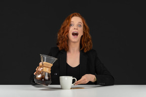 Mad looking red haired woman drinking coffee