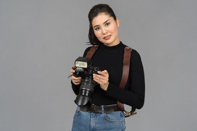 Cheerful young woman holding a camera