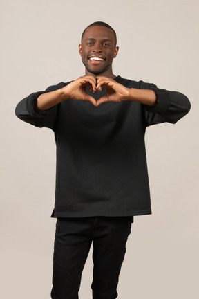 Young man making heart gesture