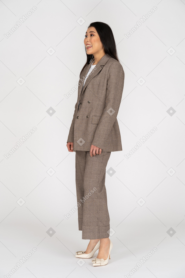 Вид в три четверти удивленной молодой леди в коричневом деловом костюме
