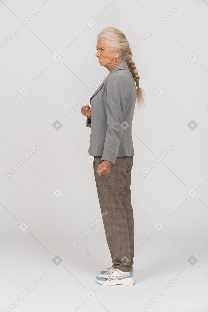 Angry old lady in suit posing in profile