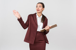 Attraente donna vestita formalmente in possesso di un blocco per appunti