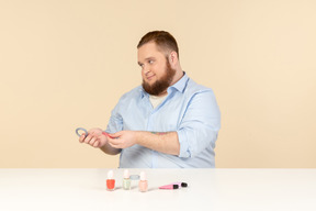 Big man sitting at the table and holding hair bands