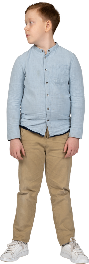Vista frontal de un niño con ropa informal mirando a un lado