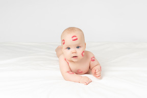 Niña con labios rojos besos acostada sobre el estómago