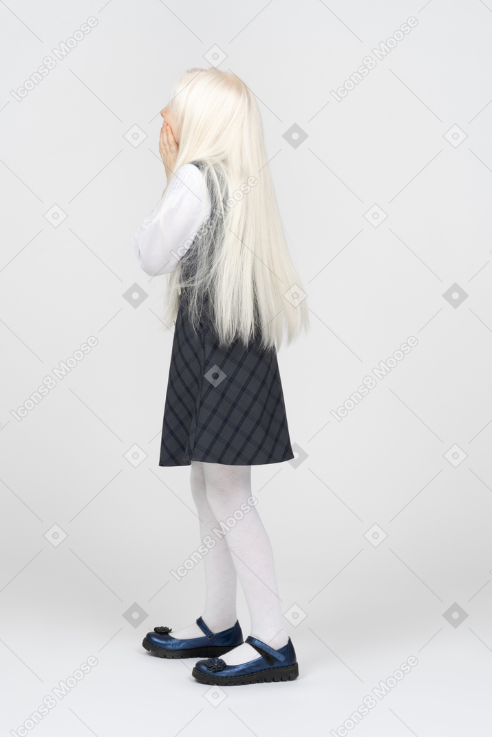 Вид сбоку школьницы с длинными платиновыми волосами