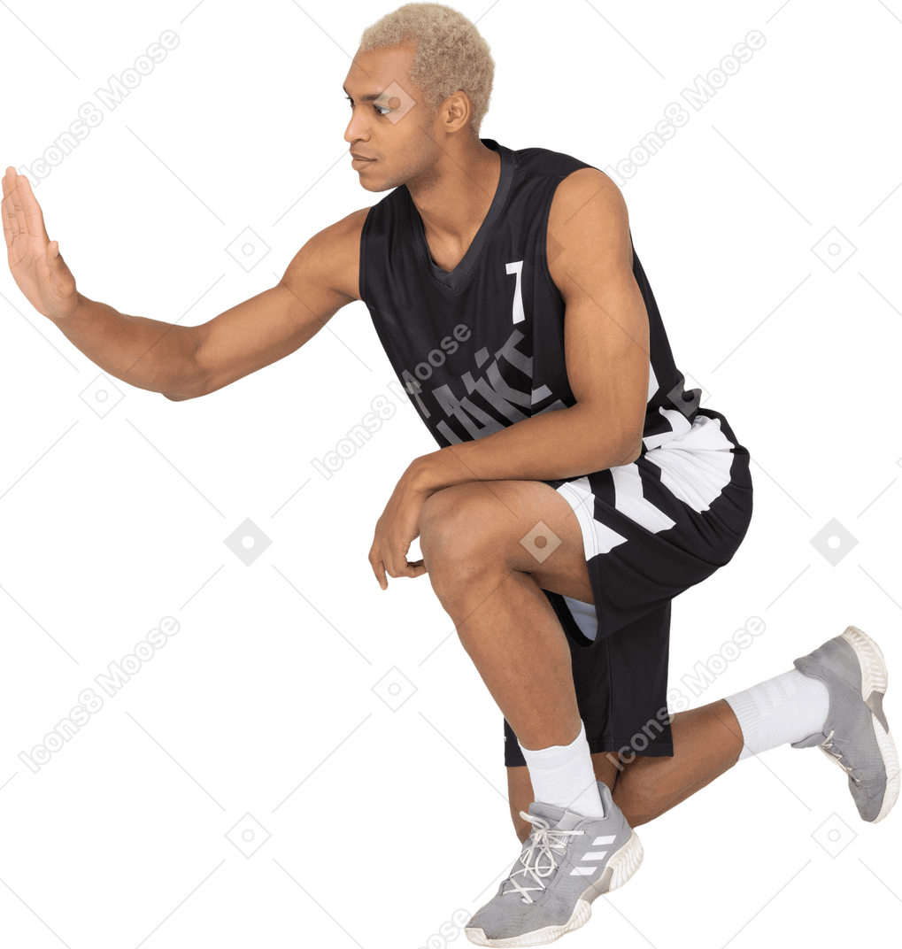 一个年轻的坐着的男篮球运动员打高五的四分之三视图
