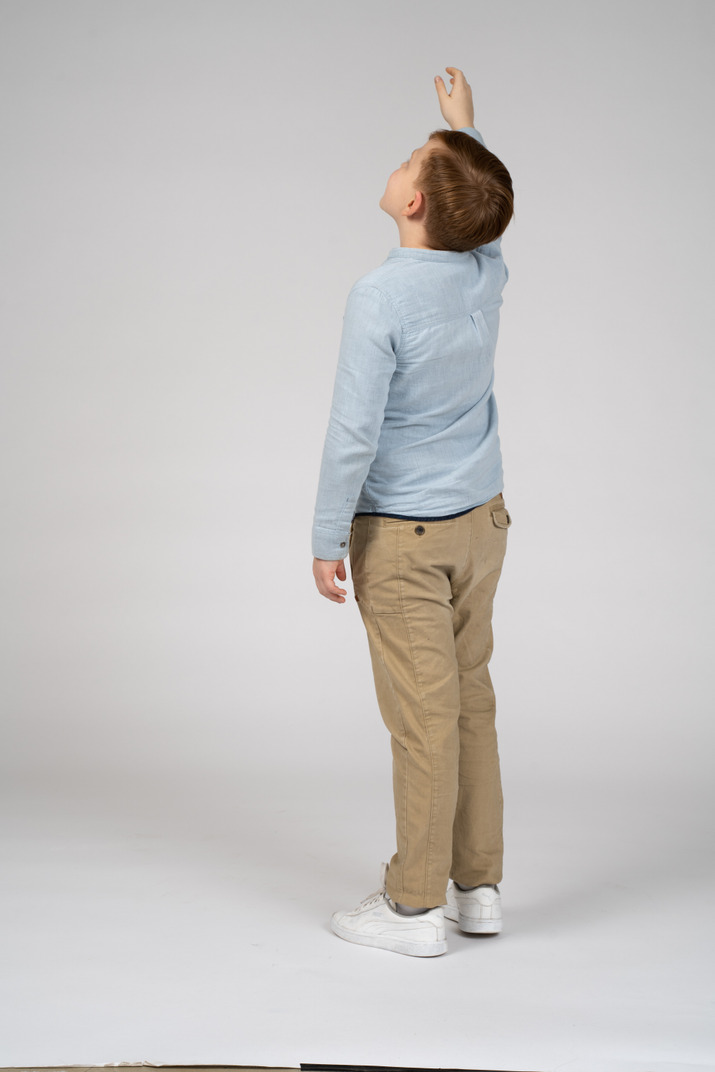 Boy standing back to camera and waving