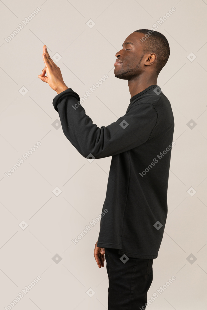 Side view of young man showing ok gesture