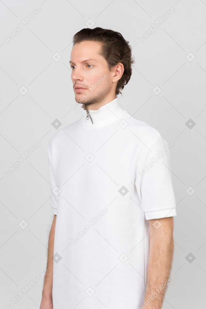 흰색 폴로 티셔츠를 입고 카메라를 향해 반쯤 서 있는 남자