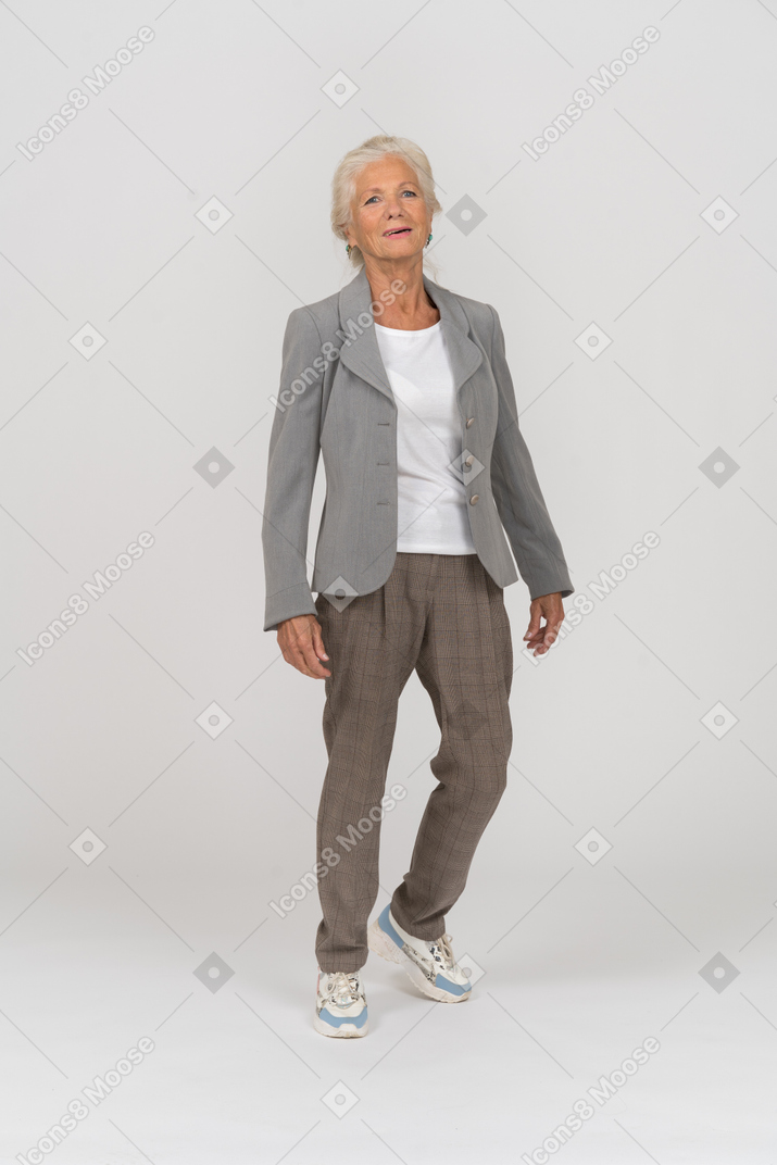 Vorderansicht einer alten dame im anzug beim gehen