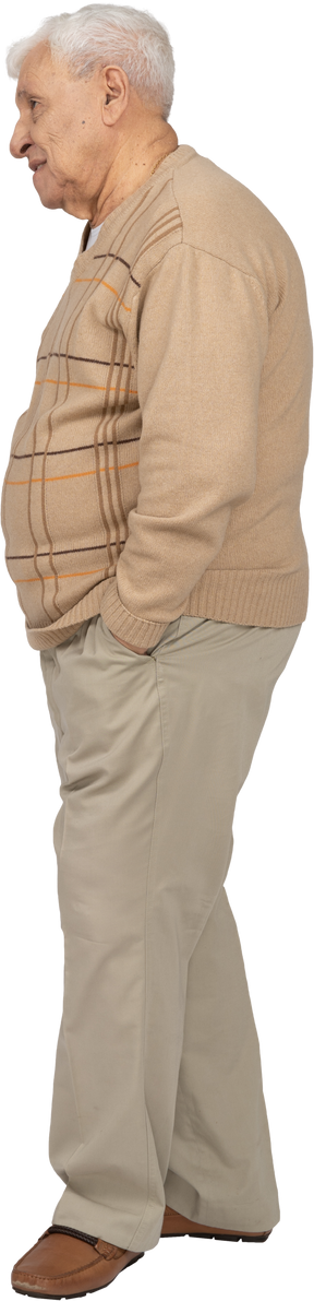Vue latérale d'un vieil homme en vêtements décontractés debout avec les mains dans les poches