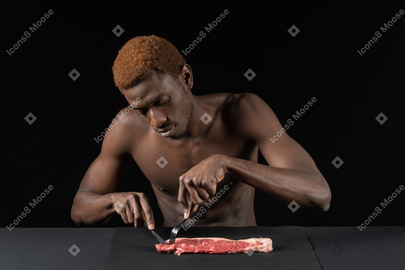 Vorderansicht eines jungen afro-mannes, der fleisch schneidet