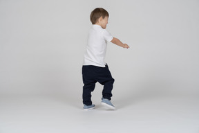 Three-quarter back view of a boy walking