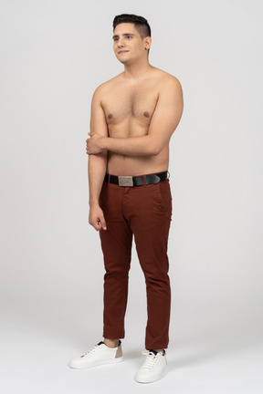 Three-quarter view of a shirtless latino man looking shy