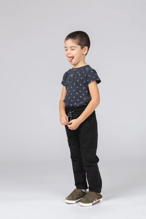 Cute boy in casual clothes showing tongue
