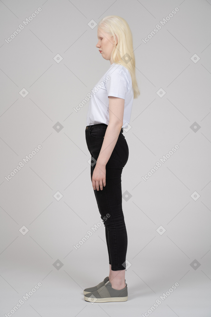 Vista lateral de uma adolescente com braços nas laterais