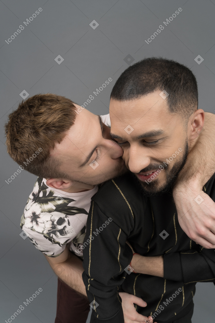 Young man kissing his boyfriend from behind