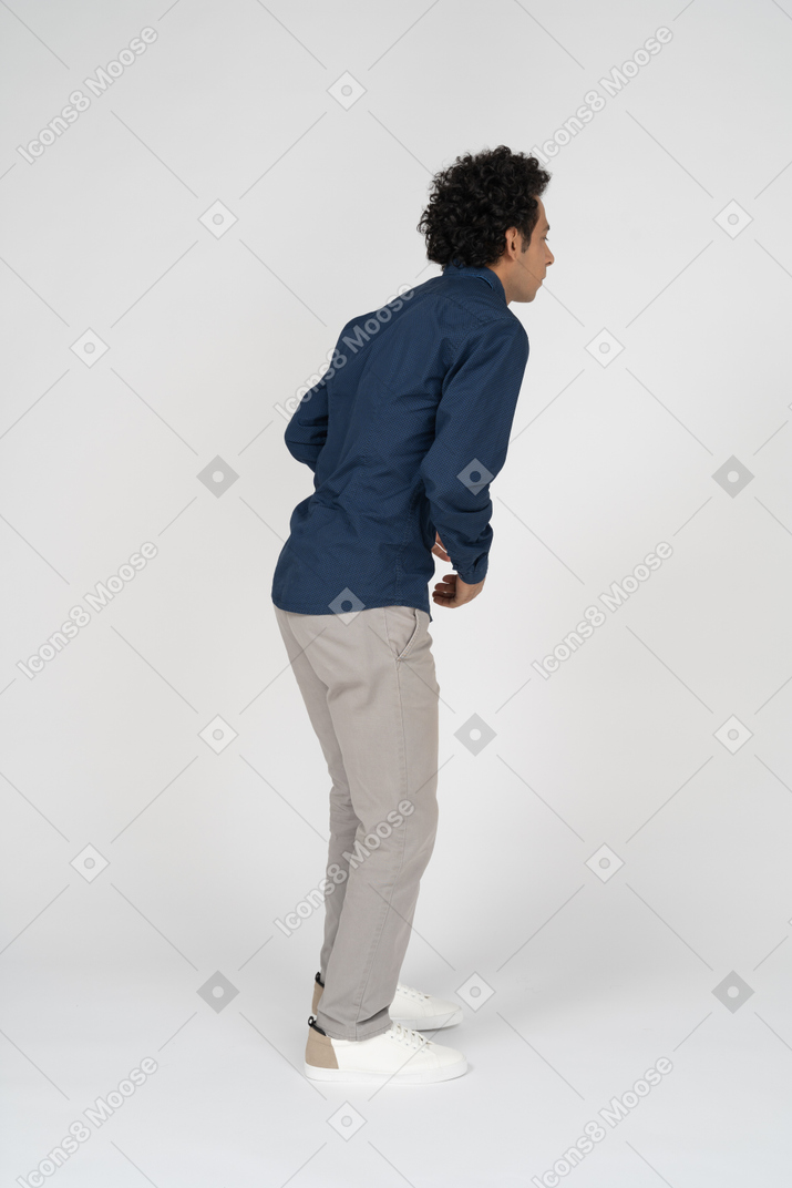 Vista lateral de um homem com roupas casuais sofrendo de dor de estômago