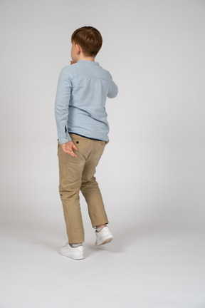 Back view of a young boy in blue shirt