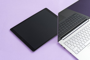 Laptop and digital tablet over lilac background