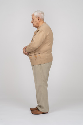 Side view of an old man in casual clothes standing still