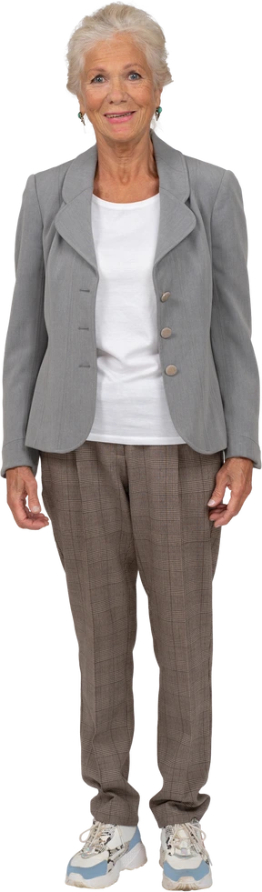 Vista frontal de una anciana feliz en traje mirando a la cámara