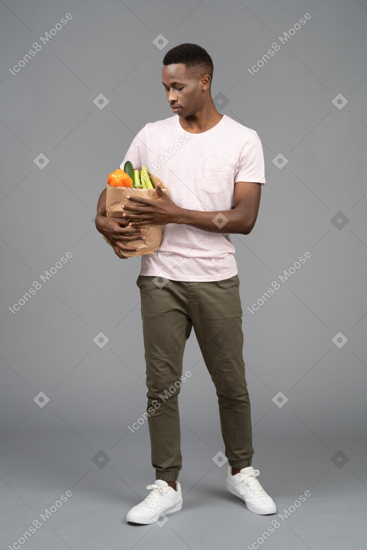Un joven llevando una bolsa de supermercado