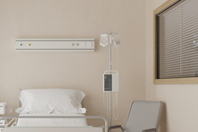 A hospital room with a bed, chair, and air conditioner