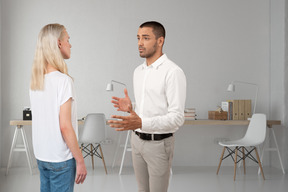 A man talking to a woman in a white room