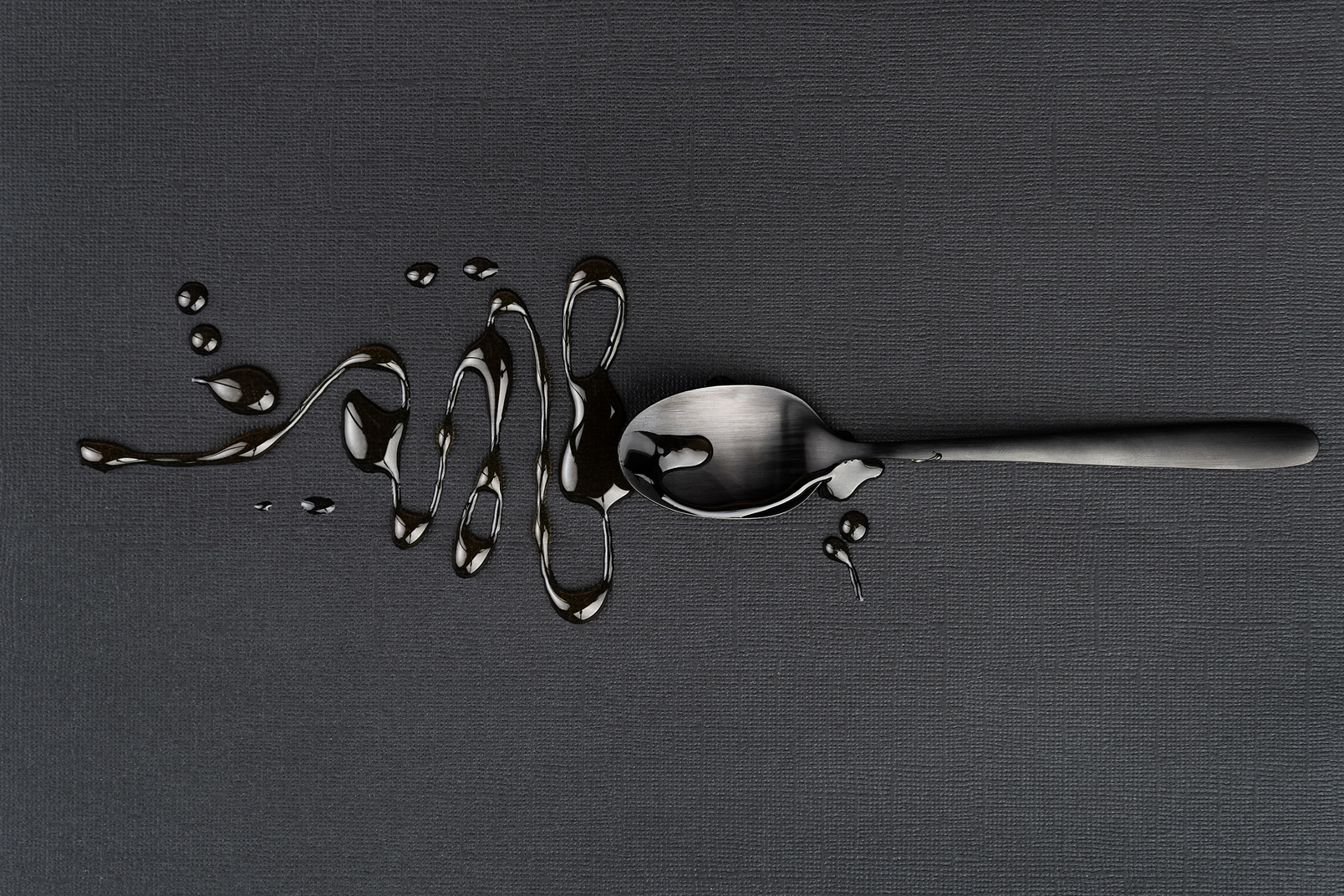 Tea spoon with liquid on the black