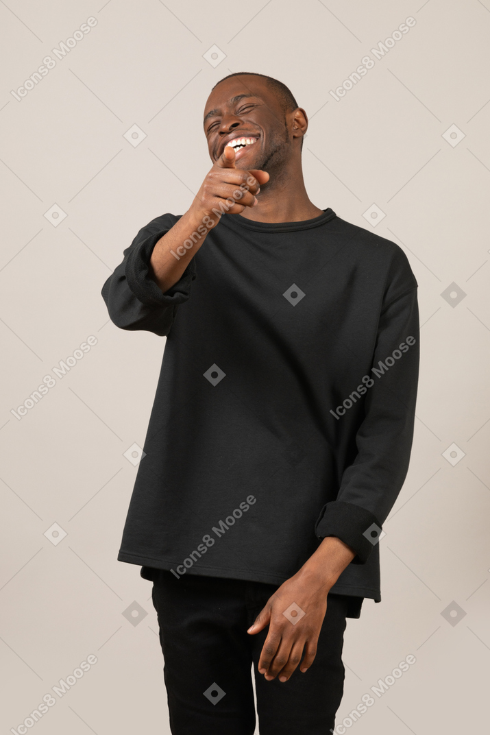 Young man laughing and pointing at something