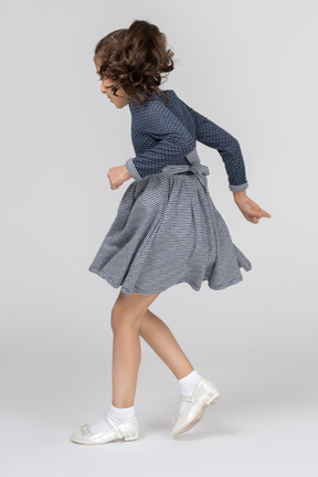 Vista lateral de una niña corriendo rápido en movimiento