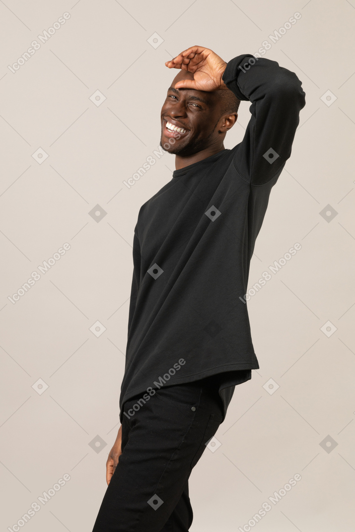 Радостный черный мужчина с рукой на лбу